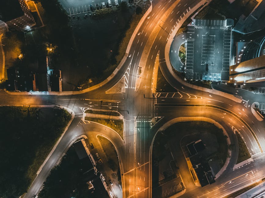 A captivating aerial view of a glowing street junction at night, showcasing an intricate network of roads.
